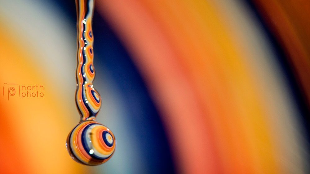 Macro photography of a water droplet on a rainbow background