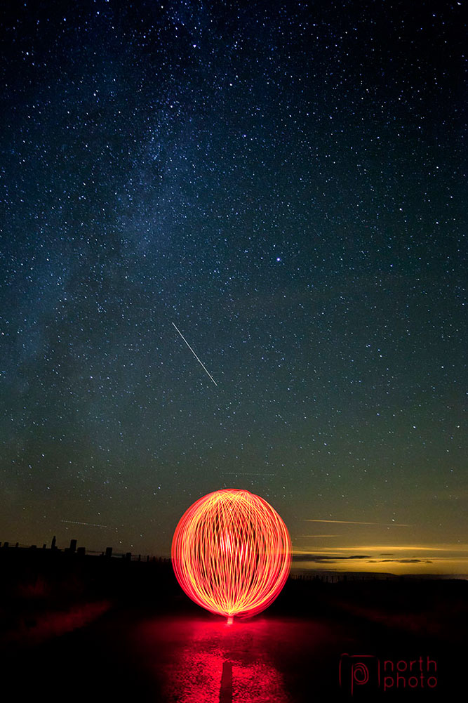 A light ball under the Milky Way, with a shooting star